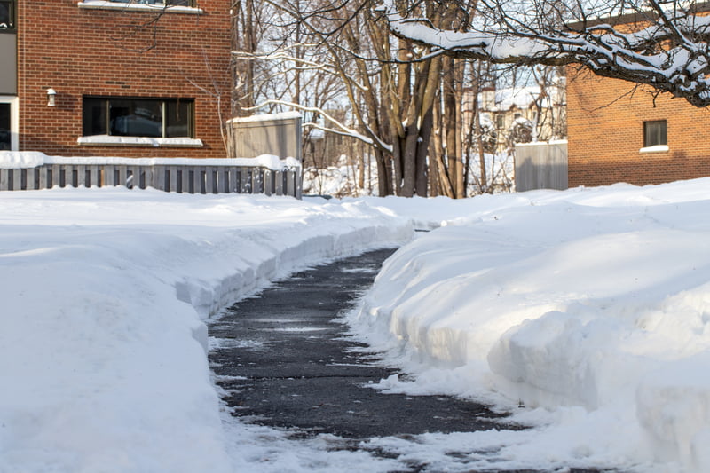 Road with snow on the sides near houses in winter.